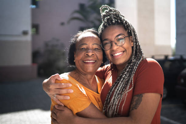 Portrait of grandmother and granddaughter embracing outside